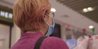 亚洲女性戴着防毒面具在商场购物