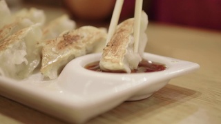 Woman dipping dumplings in soysauce视频素材模板下载