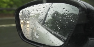 雨中行驶在高速公路上的汽车后视镜反射