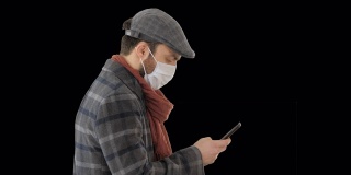带着医用口罩走路用智能手机的时尚男士，阿尔法频道