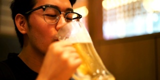 亚洲游客在餐厅喝日本啤酒