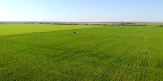 用农用拖拉机鸟瞰蓝天下的绿色麦田