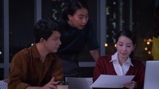 亚洲女性领导者建议ux/ui设计师在现代办公室的桌子上进行手机应用界面线框设计。工作到很晚Creative digital development agency视频素材模板下载