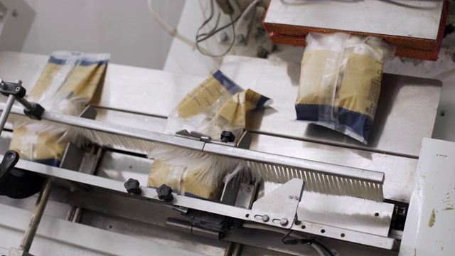 速冻饺子包装机。为生产半成品的现代化工厂。传统意式馄饨。饺子工厂的自动机器生产过程。