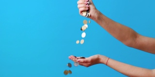 一个女人在蓝色的背景上一只手接一只手地扔硬币