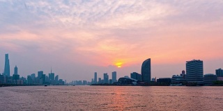 时间流逝的镜头在上海城市日落与外滩天际线和黄浦江的背景，货船在河上航行，从日落到蓝色小时，4k视频，b卷拍摄。