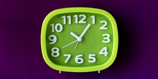绿色时钟与白色数字和箭头孤立在紫色背景，时间流逝