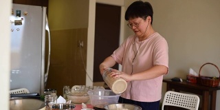 一个亚洲华人在家做母亲准备面团