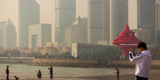 青岛阳光灿烂的日子著名的海湾纪念碑拥挤的海滩时间流逝全景4k中国