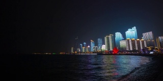 夜晚的时间照亮了青岛市区著名的奥林匹克湾，时光流逝4k中国全景