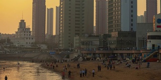 日落时间青岛城市拥挤的海滩湾时间流逝全景4k中国