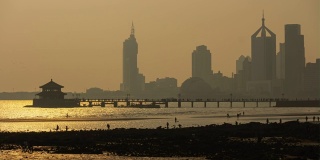 日落时间青岛城市景观著名的海滩地段潮汐码头时间流逝全景4k中国