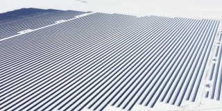 空中视角太阳能电池板农场绿色能源在冬季雪晴天