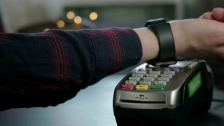 一名男子在咖啡馆用电子智能手表付款。非接触式NFC技术。网上购物使用现代技术。消费主义网上购物。男人正在用智能手表支付视频素材模板下载