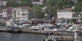 港街。码头上有许多小船，飞着许多海鸥。整洁的房子和人们走路吗
