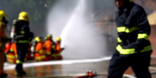 消防队员使用消防水龙带灭火的模糊镜头