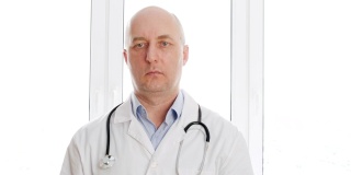 身穿医袍的男医生，在白色窗口背景下，用声内窥镜扫过虚拟屏幕。医务人员在医院办公室使用手指触屏。