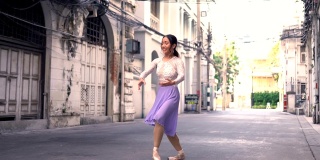 年轻美丽的芭蕾舞演员沿着街道跳舞