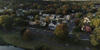 鸟瞰图公园和住宅区在斯普林菲尔德，新泽西州，美国，日落。无人机视频与上升和倾斜的摄像机运动。