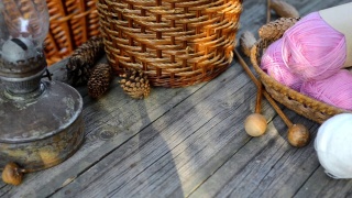 手把编织的东西放在篮子上，把白色的毛线球放在有粉色球的篮子旁边视频素材模板下载