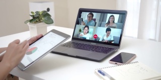 女商人在视频会议上谈论销售报告的背景。亚洲团队使用笔记本电脑和平板电脑进行在线视频会议。在家工作，远程工作和自我隔离。