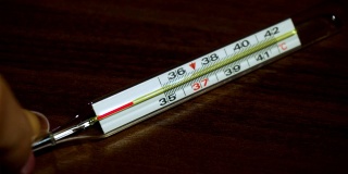 在全球范围内，COVID-19大流行期间，女性手上的医用体温计显示正常温度为36.6摄氏度