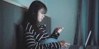年轻的亚洲女人用笔记本电脑购物用信用卡录像