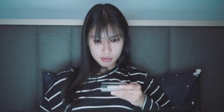 年轻的亚洲女人用笔记本电脑购物用信用卡录像