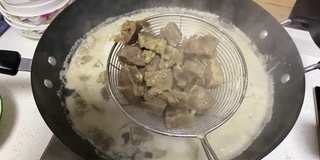 用滤锅搅拌牛肉，煮牛肉的慢动作视频