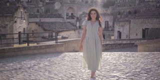 美丽优雅的年轻女子走在意大利马泰拉古城