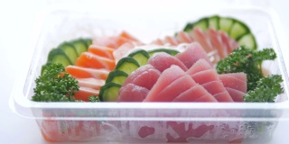 一套寿司装在塑料盒里，送回家准备吃的健康快餐