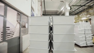 在电冰箱厂搬运电冰箱零件的装配线工人。视频素材模板下载