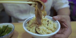 成熟的商人用筷子吃饭