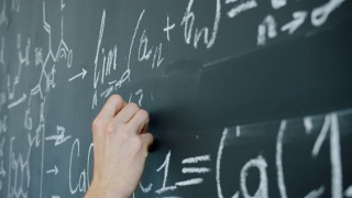 男生在黑板上写数学方程式的特写视频素材模板下载