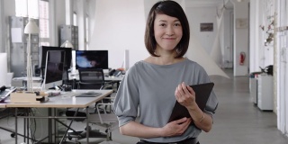在一家初创公司的办公室里，拿着数字平板电脑的女性高管