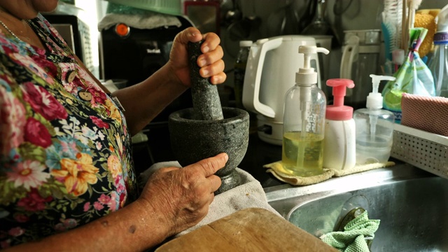 年长的亚洲妇女在家做饭