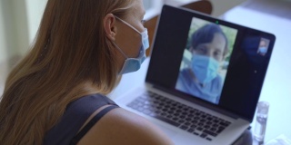 一名年轻女子在冠状病毒自我隔离期间，坐在家里通过视频会议进行交谈。社会距离的概念
