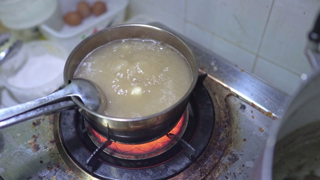 近距离拍摄烧肉骨茶的场景:在草药排骨汤中煮大蒜，食物加工，马来西亚和新加坡的传统菜肴，烹饪步骤，食物准备，其中一道著名的菜