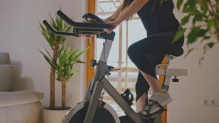 SLO MO女人调整健身自行车视频素材模板下载