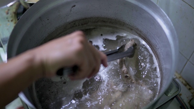 近距离拍摄肉骨茶的烹饪场景:用草本排骨熬制排骨汤，食物加工，马来西亚和新加坡的传统菜肴，烹饪步骤，食物准备，其中一道著名的菜肴。