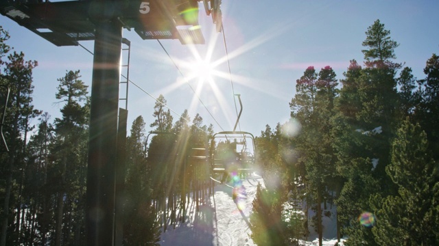 滑雪运动员在博尔德附近的埃尔多拉滑雪度假村滑雪缆车的慢动作拍摄，在一个晴朗，阳光明媚的日子