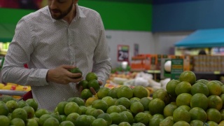 一个年轻人在超市选购酸橙视频素材模板下载