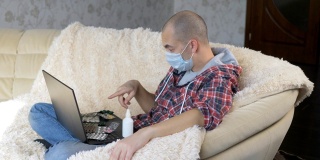 一名男子戴着防护面具坐在沙发上，通过视频链接向医生咨询如何治疗这种疾病。