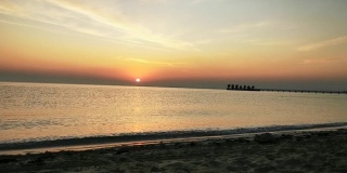 冬季在卡塔尔海滩上的日出短视频。小波浪碰岸