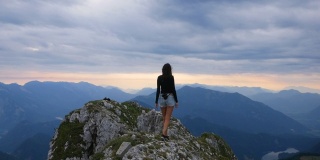 年轻漂亮的徒步女孩在奥地利沙夫伯格山顶行走。60帧/秒的慢动作镜头。