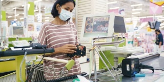 亚洲妇女购买和支付在商店的商品与口罩保护免受冠状病毒和流感的健康生活。