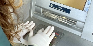 女性用手在ATM键盘上输入PIN码。
