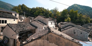 中国老安徽风格的砖瓦屋顶房屋，以山为背景的春天