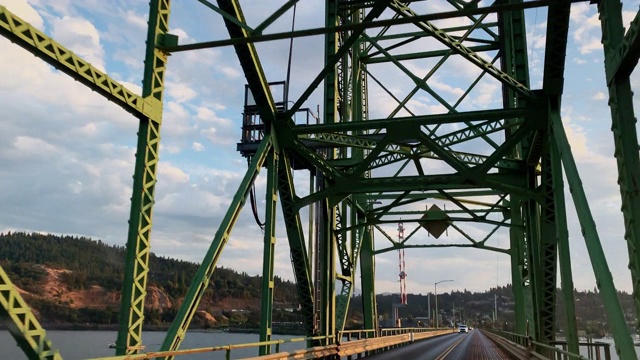 车辆视角拍摄的驾驶在哥伦比亚河胡德河桥上与交通在俄勒冈州在日落