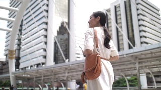 亚洲女商人在步行上班时使用智能手机视频素材模板下载